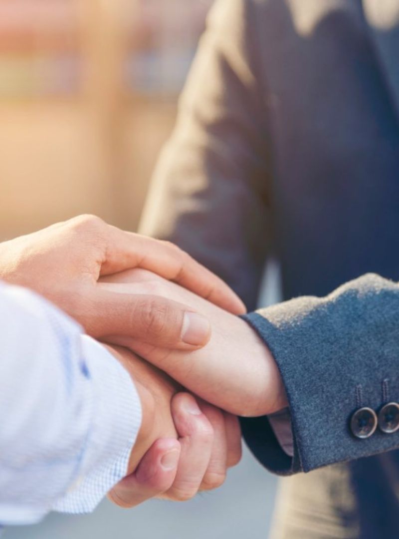 dos hombres cruzando las manos